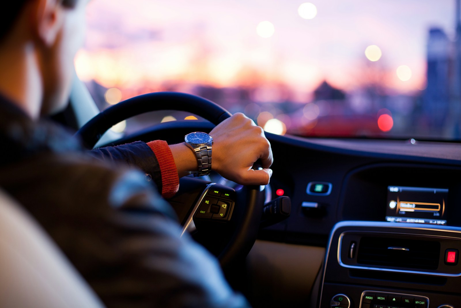 man driving a car protected by auto insurance wearing wrist watch